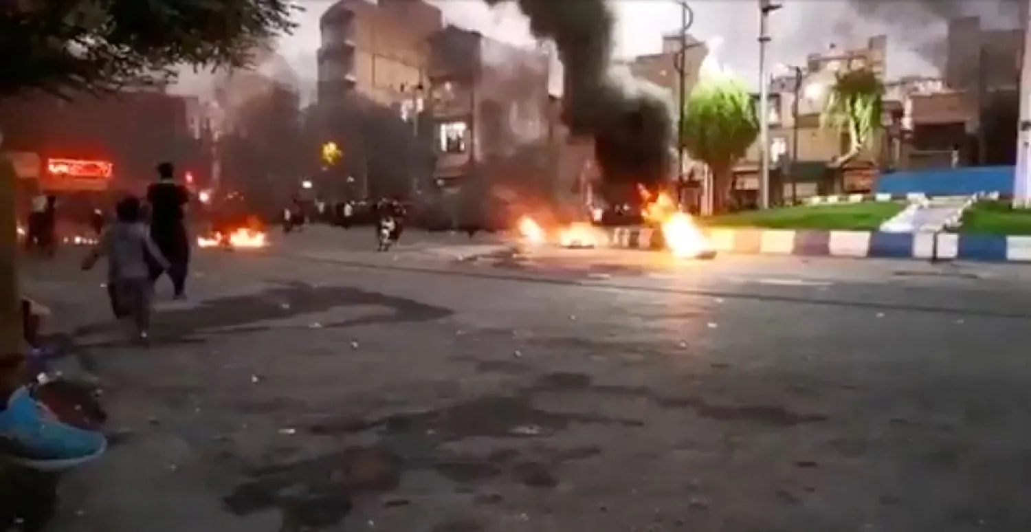 A person rides a motorcycle amidst a fire during a protest over the death of Mahsa Amini, in Javanrud, Iran October 9, 2022 in this screengrab from a social media video obtained by Reuters. (Reuters)