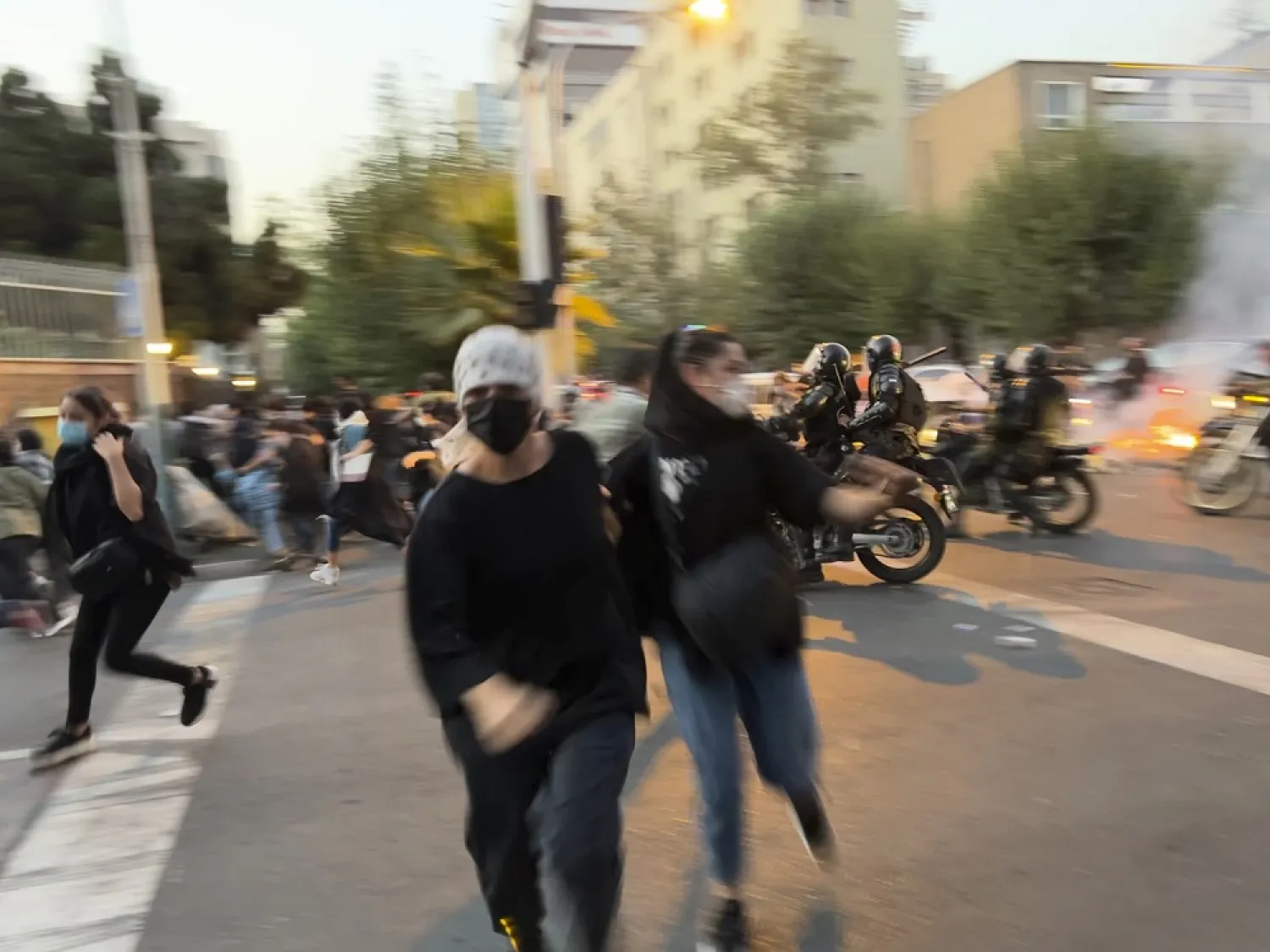 In this Monday, Sept. 19, 2022, photo taken by an individual not employed by the Associated Press and obtained by the AP outside Iran, women run away from anti-riot police during a protest of the death of a young woman who had been detained for violating the country's conservative dress code, in downtown Tehran, Iran. (AP)