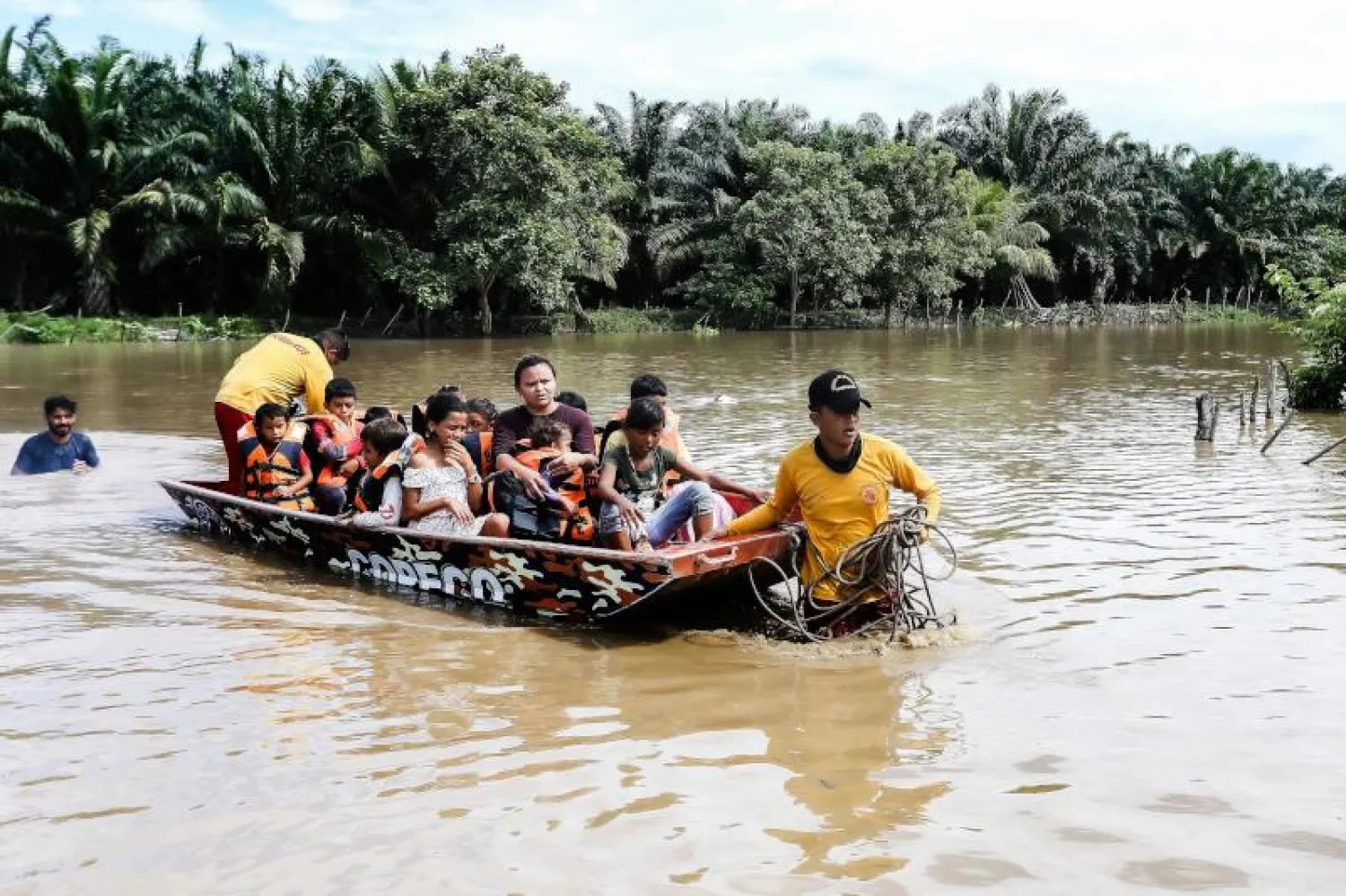 أشخاص يُنقلون بواسطة قارب وسط إعصار جوليا الذي ضرب هندوراس (أ.ف.ب)