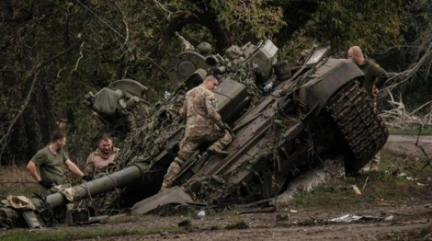 Ukraynalı askerler 30 Eylül'de Harkov yakınlarında harap olmuş bir Rus tankının üzerinde (AFP)