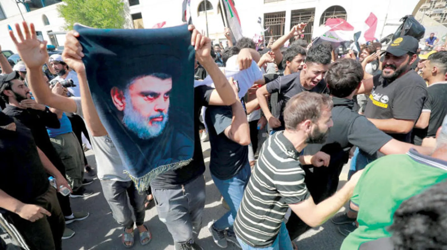 أحد أنصار الصدر يرفع صورته خلال مظاهرة احتجاجية في بغداد 28 سبتمبر (أ.ف.ب)