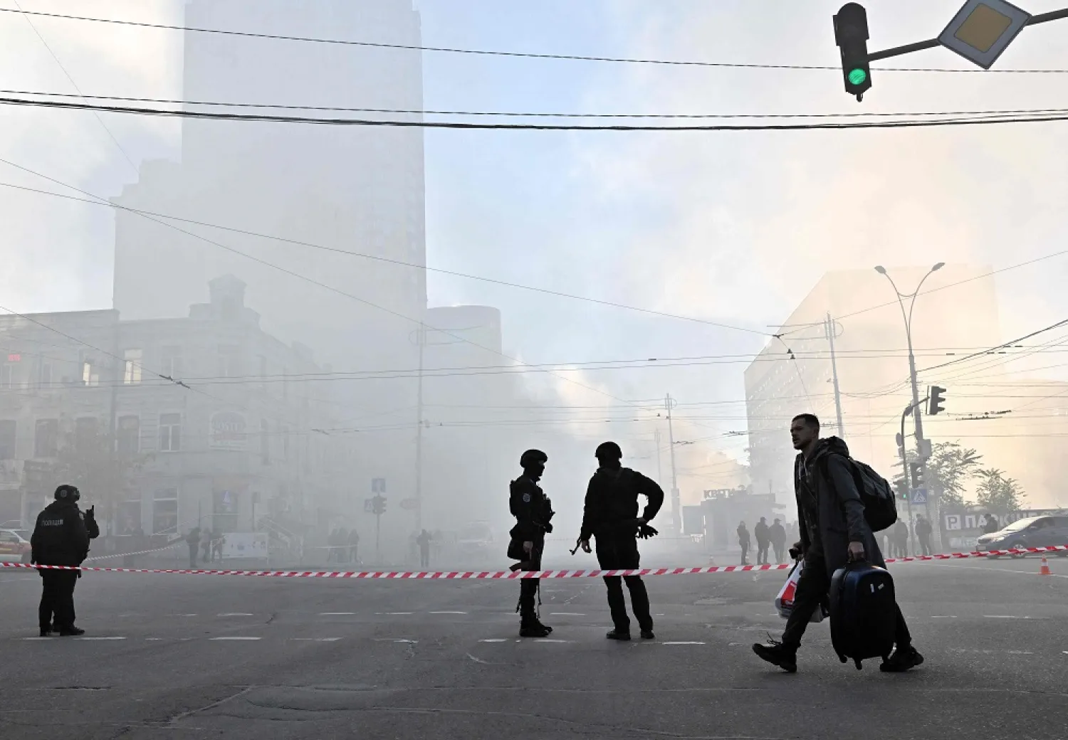 A local resident walks past police officers after a drone attack in Kyiv on October 17, 2022, amid the Russian invasion of Ukraine. (AFP)