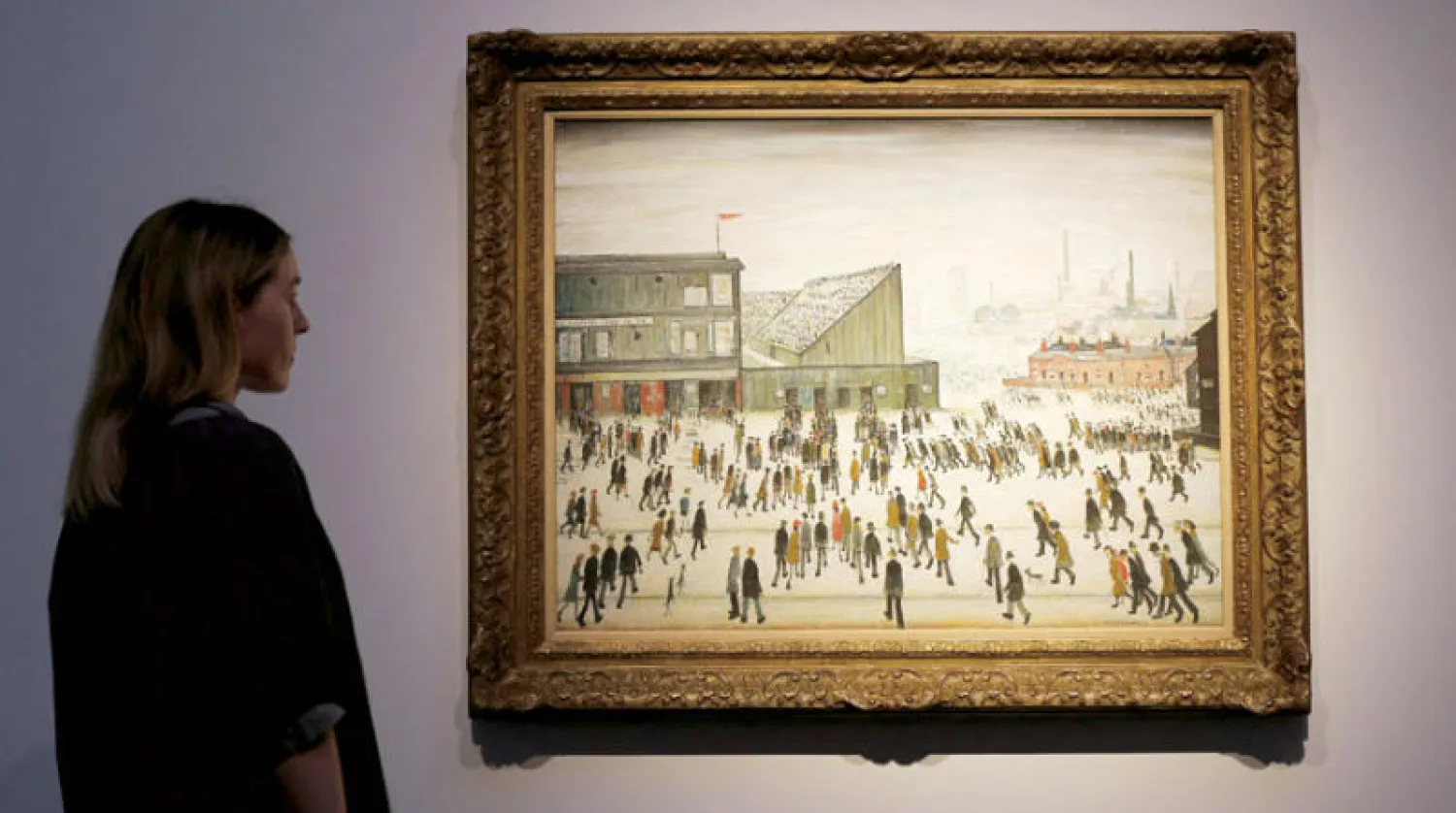 لوحة «الذهاب إلى المباراة» للفنان الإنجليزي إل إس لوري أثناء عرضها في دار كريستيز بلندن (أ.ف.ب)