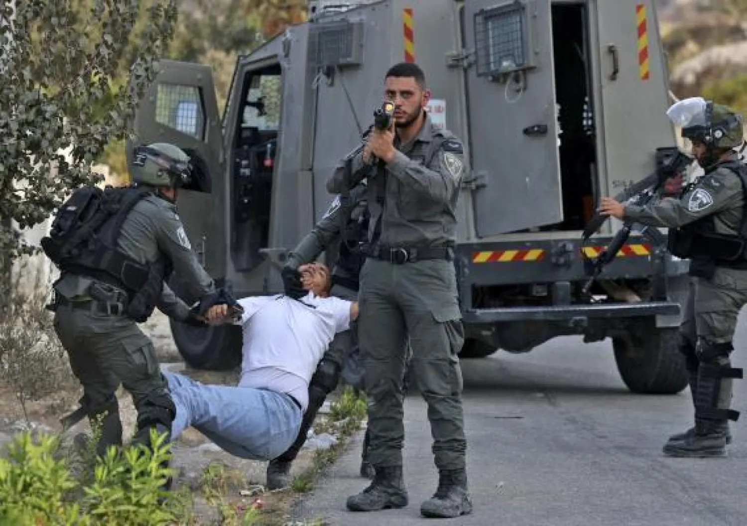 جنود إسرائيليون يعتقلون متظاهراً فلسطينياً يوم أمس الخميس عند مدخل مدينة رام الله (ا.ف.ب)