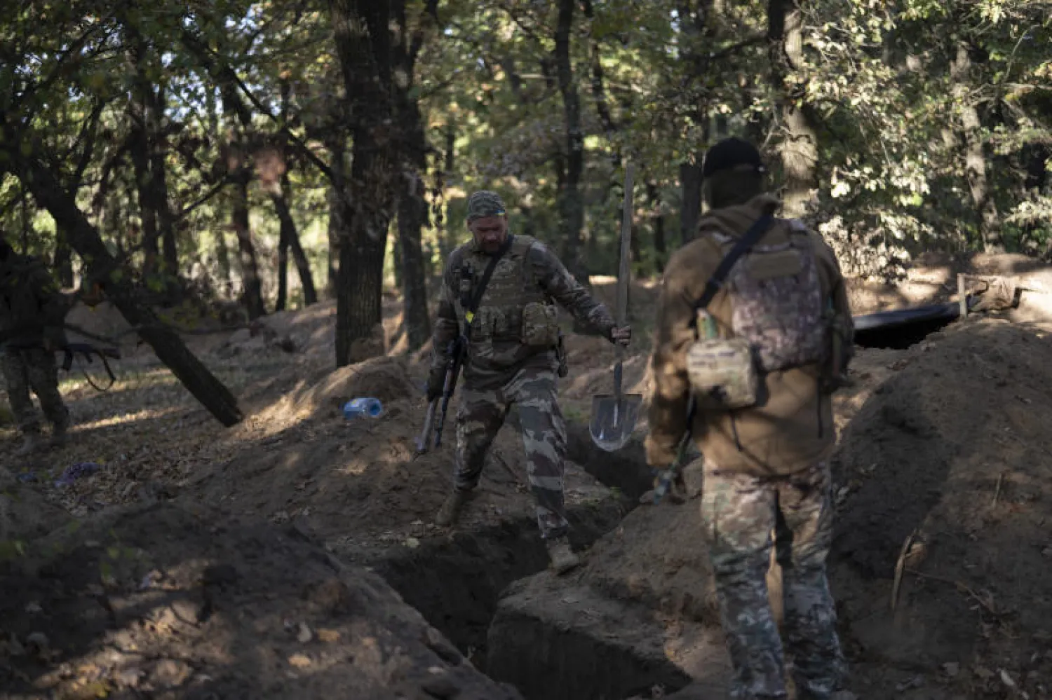 جنديان أوكرانيان يفحصان الخنادق التي حفرها الروس في منطقة تمت استعادتها في خيرسون (أ.ب)