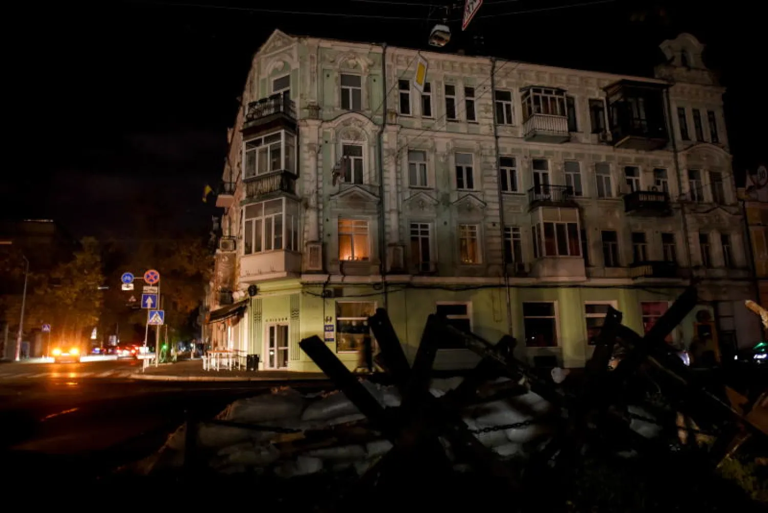 سيارة تمر من شارع مظلم بعد انقطاع الكهرباء وسط مدينة كييف (إ.ب.أ)