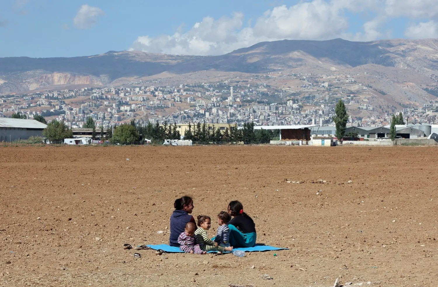 Syrian refugees sit near an informal camp, in the Bekaa Valley, Lebanon October 18, 2022. (Reuters)