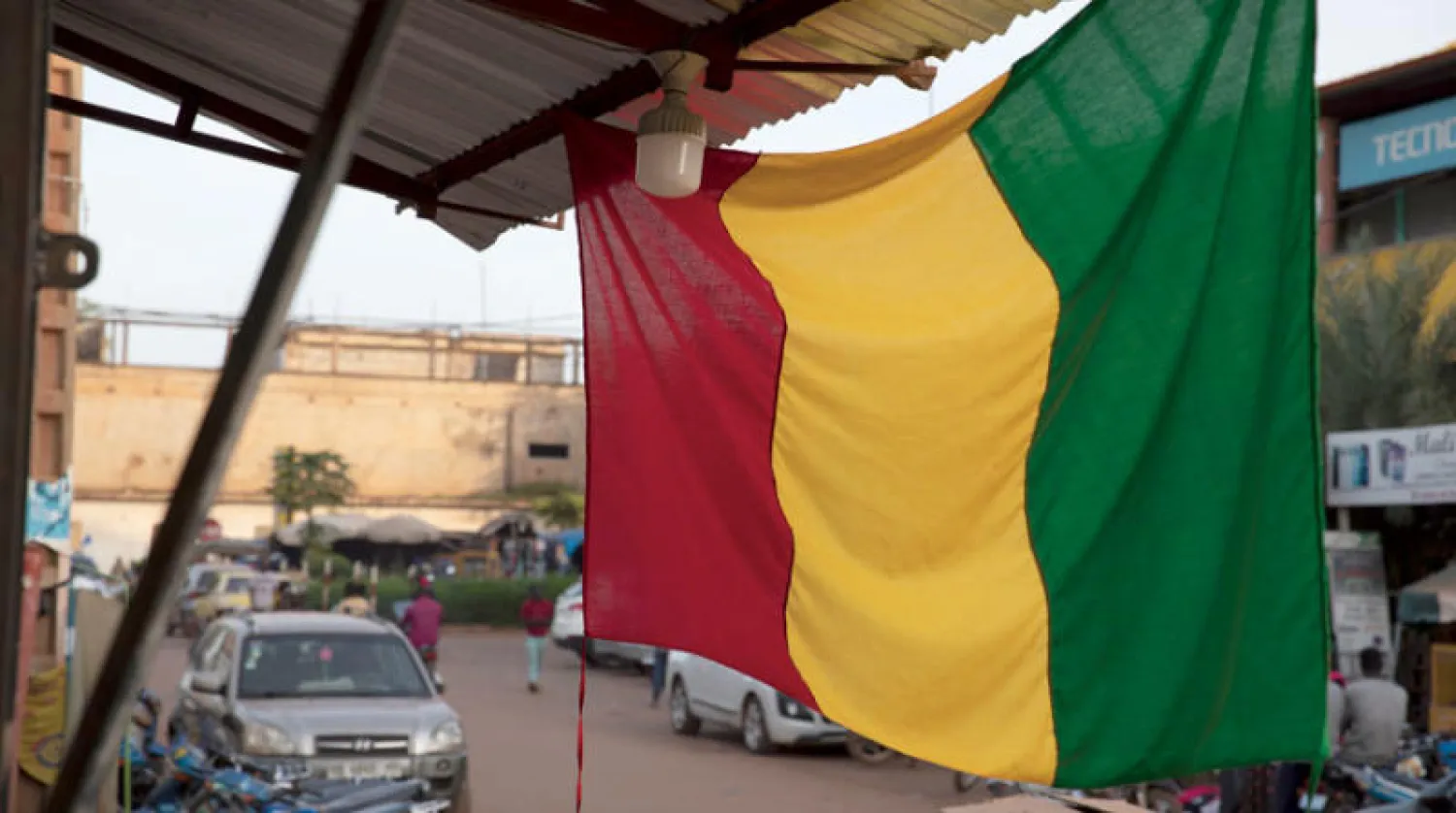 علم مالي يتدلى من متجر في وسط العاصمة باماكو أمس (إ.ب.أ)