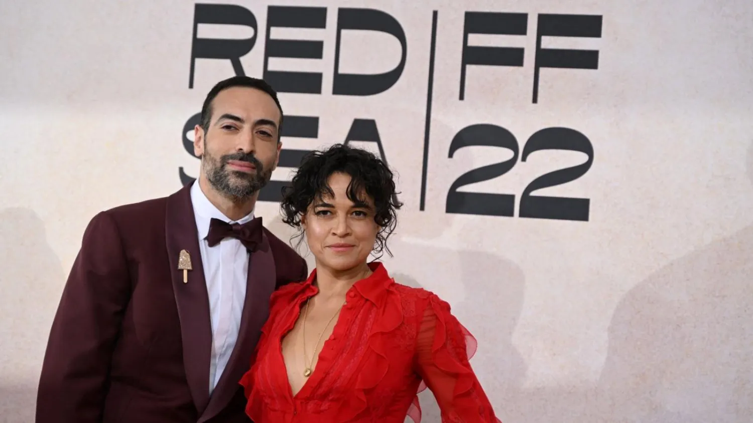 Saudi producer Mohammed Al-Turki and Hollywood actor Michelle Rodriguez pose in front of an advert for the Red Sea Film Festival at Cannes in May 2022 (AFP/Patricia De Melo Moreira)

