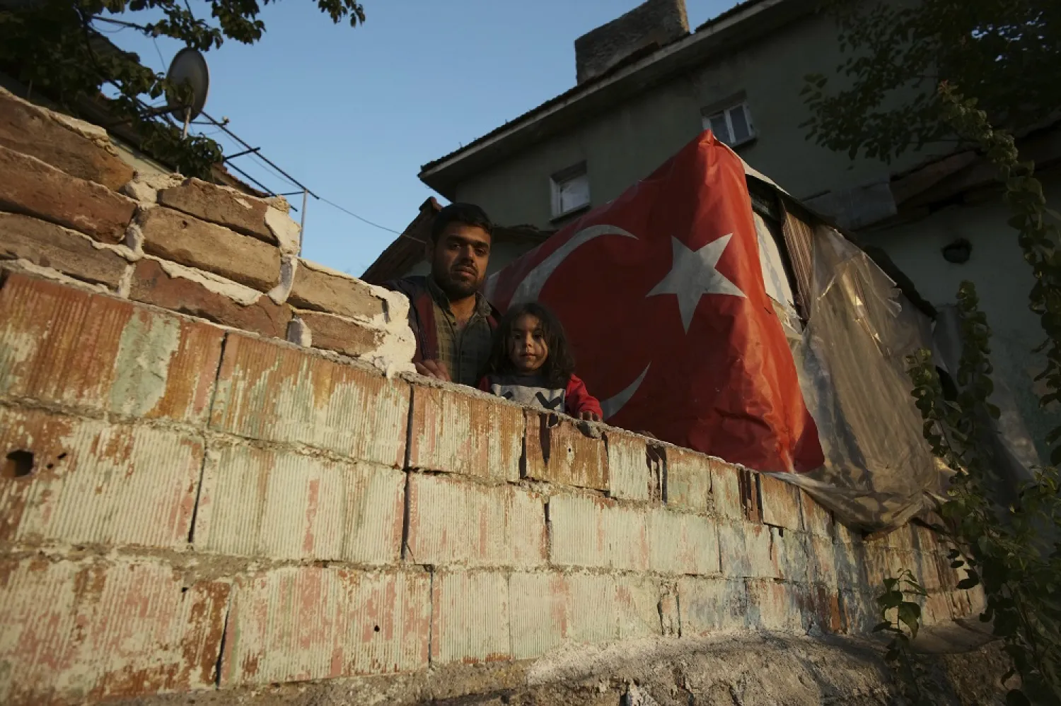 A Syrian migrant man and daughter stand in front of their shelter in Ulus district, the old part of Turkish capital Ankara, Türkiye, Sunday, Oct. 23, 2022. (AP)
