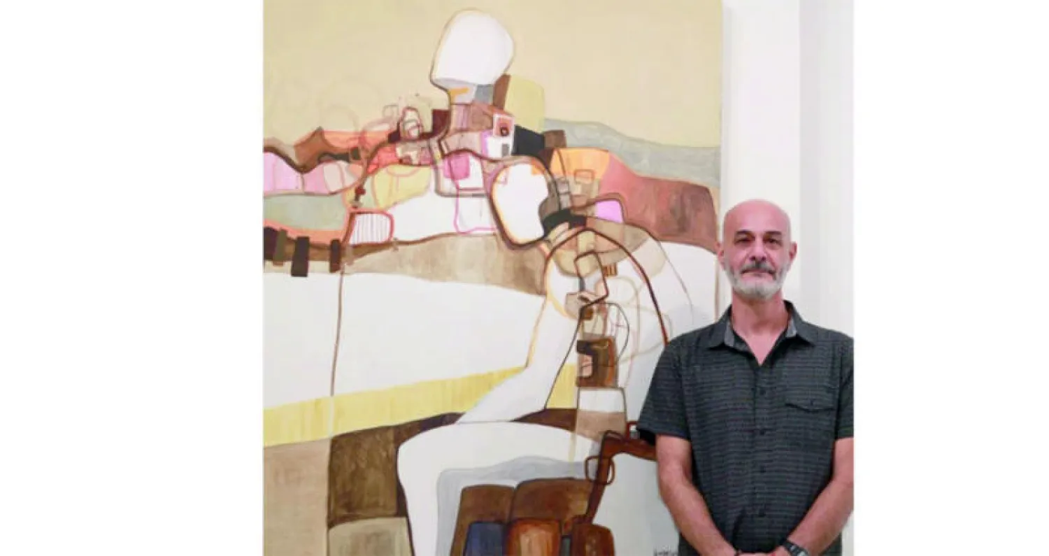 وسام بيضون أمام لوحة تحكي عن  طبيعة جبال لبنان (من المعرض)