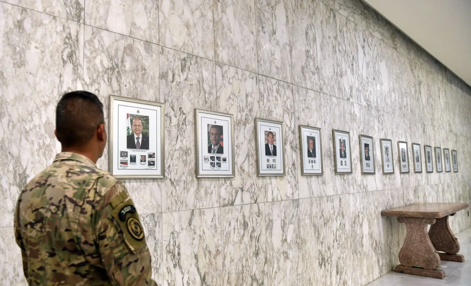 A Lebanese army member looks at pictures of former Lebanese presidents at Baabda Palace, east of Beirut, Lebanon, 01 November 2022. (EPA)