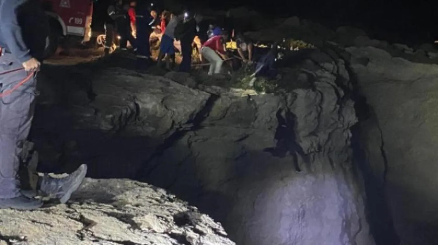 Yetkililer ve çok sayıda vatandaş, bir Yunan adası yakınlarında bir teknenin batması üzerine bir göçmeni kurtarmaya çalışıyor (AP-Arşiv)