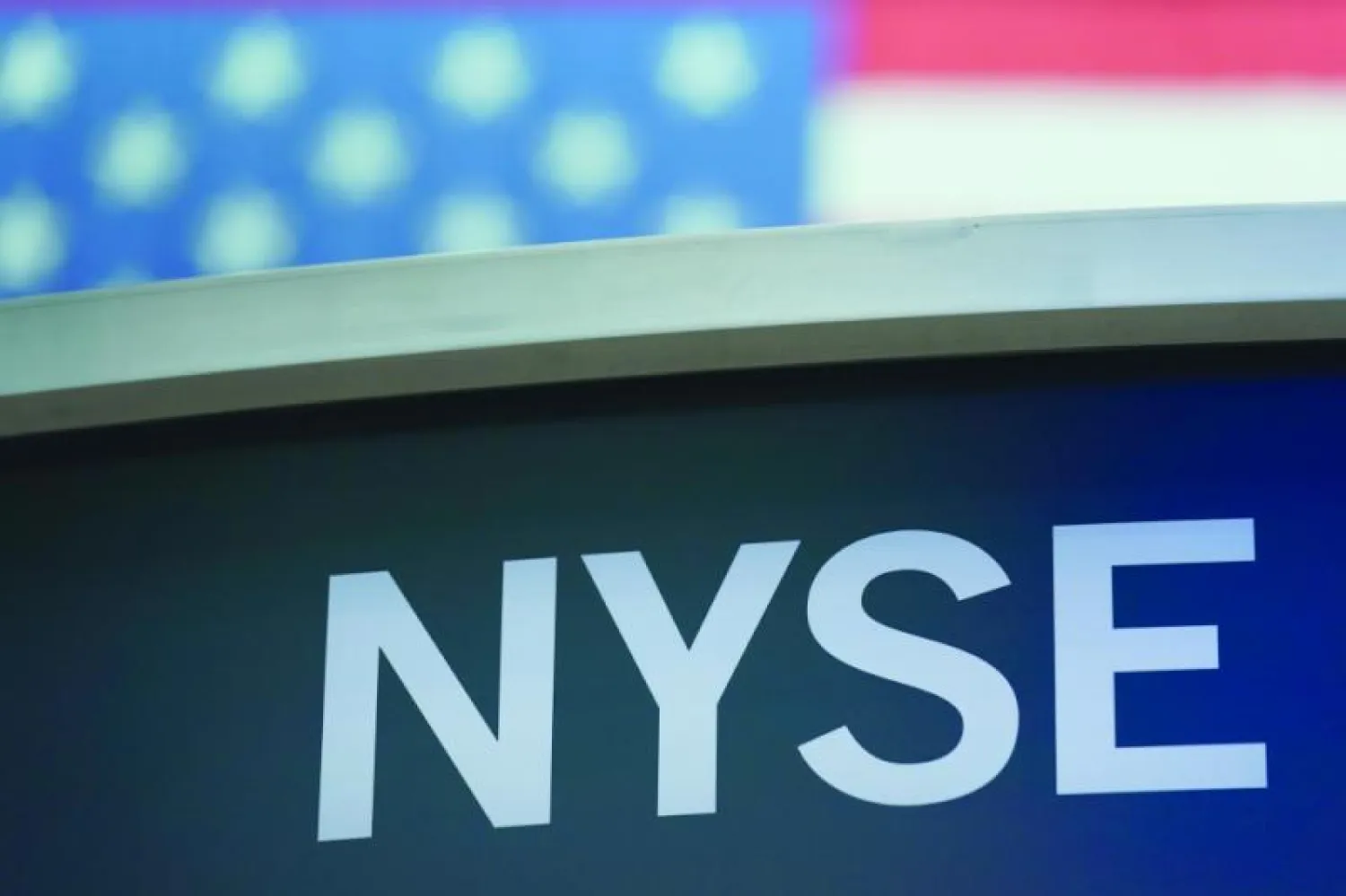 شعار بورصة نيويورك يظهر في وول ستريت حيث حسنت الاسهم من حركتها في بداية التداولات أمس (أ ب)