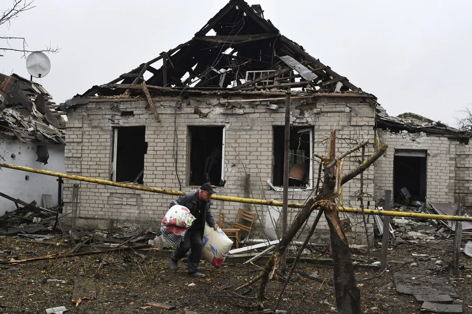 A man carries pillows from his destroyed apartment building after Russian shelling in Pokrovsk, Donetsk region, Ukraine, Friday, Nov. 4, 2022. (AP)