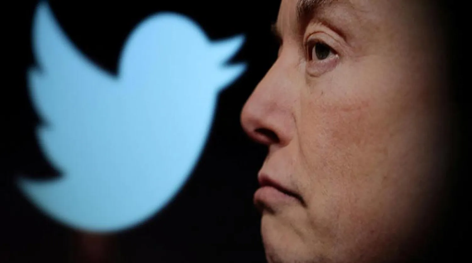 Elon Musk, Twitter logosunun yanında görünüyor (Reuters)