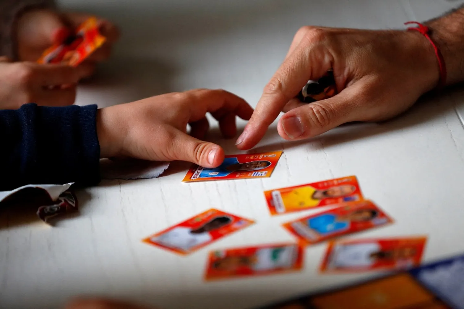 Lucas Perrone, 39, and his kids look at football World Cup stickers in Buenos Aires, Argentina September 16, 2022. (Reuters)