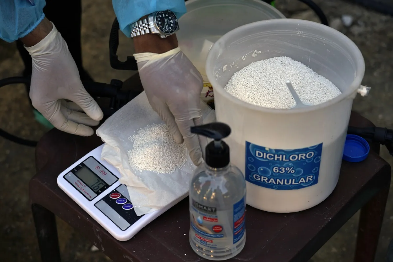 UNICEF health workers mix chlorine and fresh water to sanitize tents and bathrooms at Syrian refugee camp in response to a cholera outbreak in Bhanine village, in the northern Akkar province, Lebanon, Tuesday, Oct. 18, 2022. (AP)
