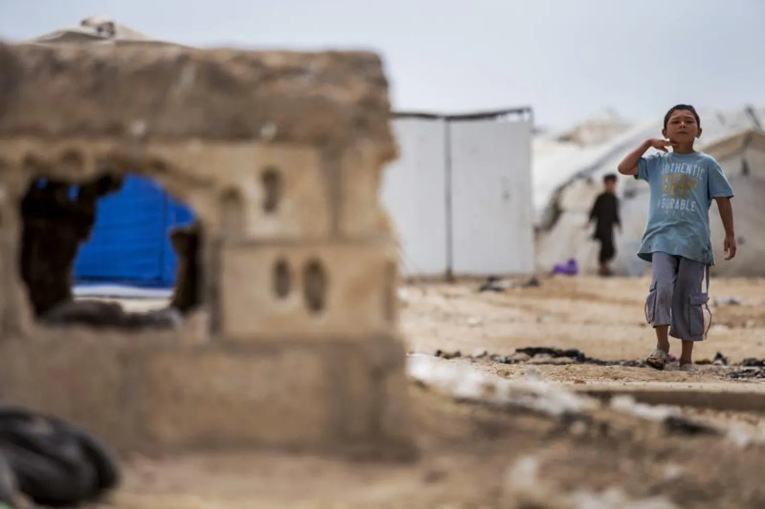 A boy gestures with his hand on his neck in an indication of the threat of beheading, at al-Hol camp, which houses families of ISIS members, in Hasakeh province, Syria, Saturday, May 1, 2021. (AP Photo/Baderkhan Ahmad)
