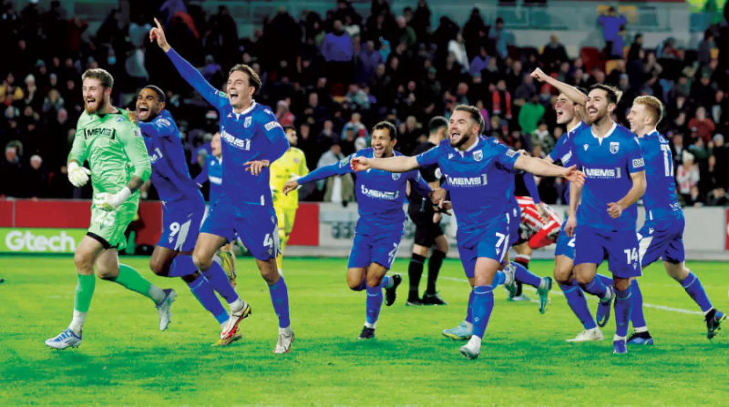 لاعبو فريق غيلينغهام يحتفلون بانتصارهم على برنتفورد والتأهل للدور الرابع (رويترز)