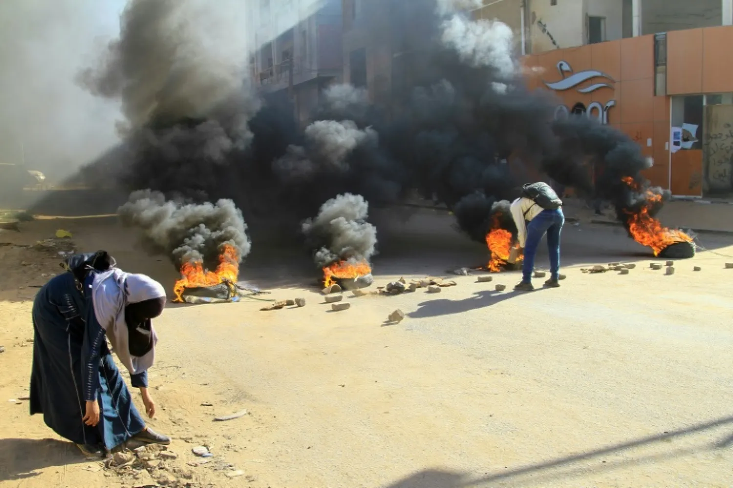 Tyres were set on fire by protesters angry at last year's military coup in Sudan to block roads in Khartoum - AFP