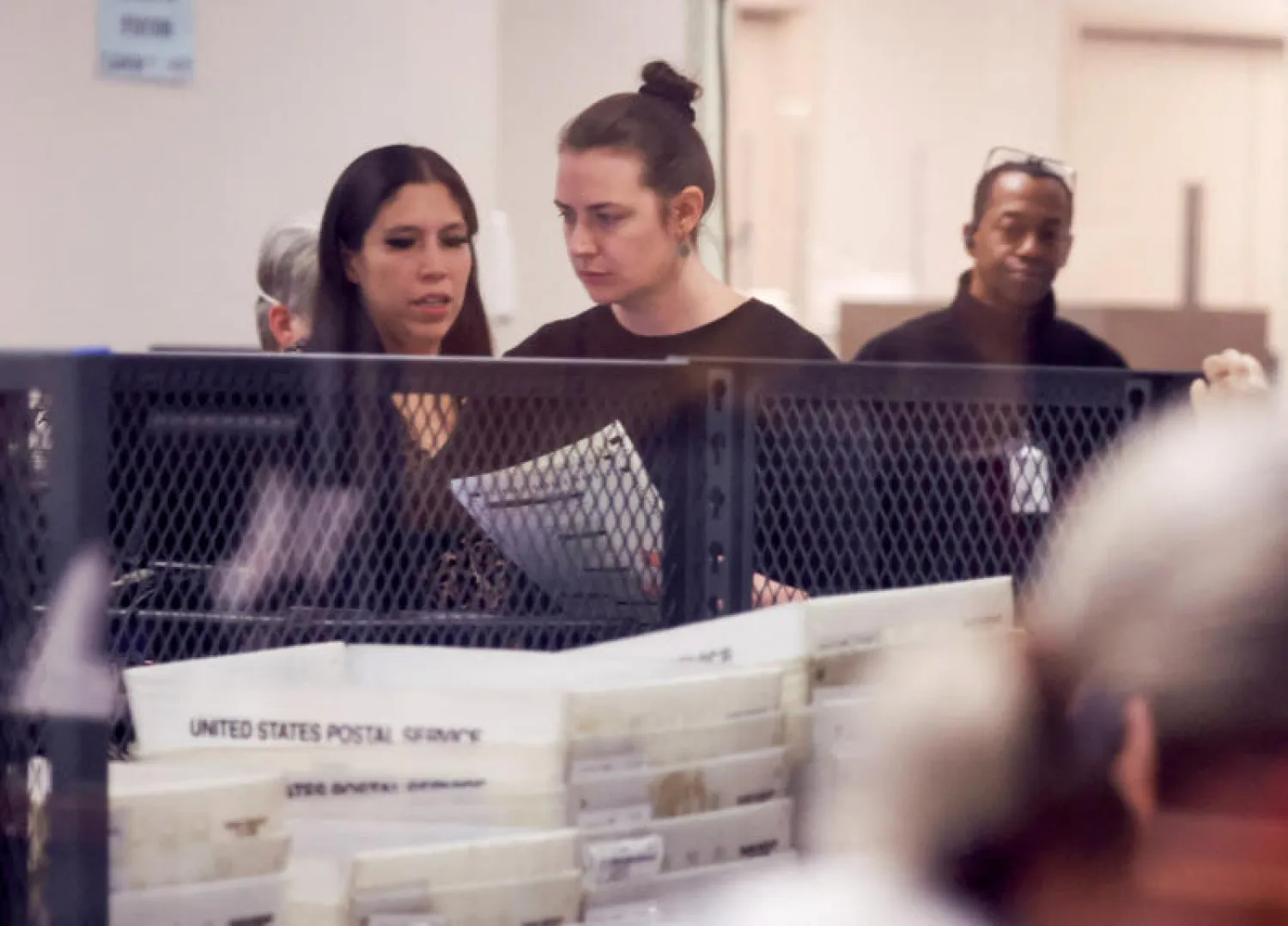 موظفون يعملون في جمع الأصوات بمركز اقتراع في أريزونا (رويترز)