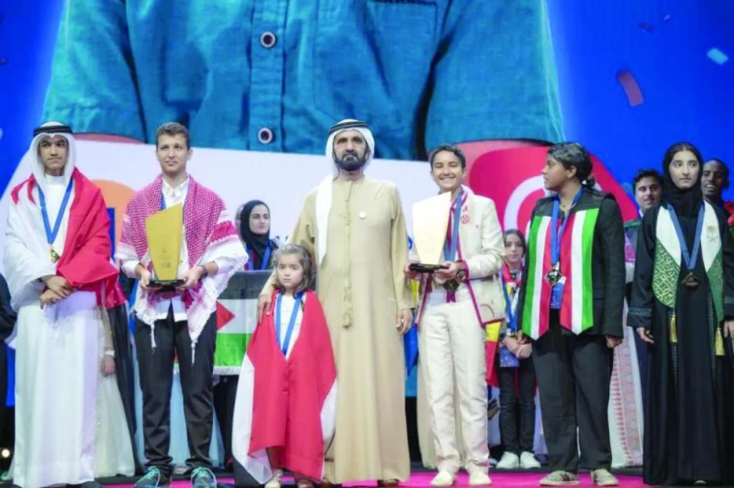 الشيخ محمد بن راشد خلال تتويج الطفلة السورية شام بجائزة المركز الأول من تحدي القراءة العربي أمس في دبي (الشرق الأوسط)