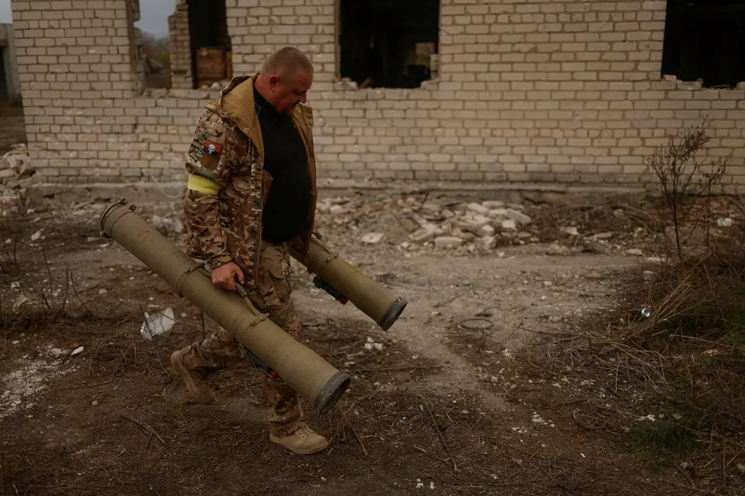 A Ukrainian serviceman carries captured anti-tank grenade launchers at a former position of Russian soldiers in the village of Blahodatne, retaken by the Ukrainian Armed Forces a day ago, amid Russia's attack on Ukraine, in Kherson region, Ukraine November 11, 2022. (Reuters)