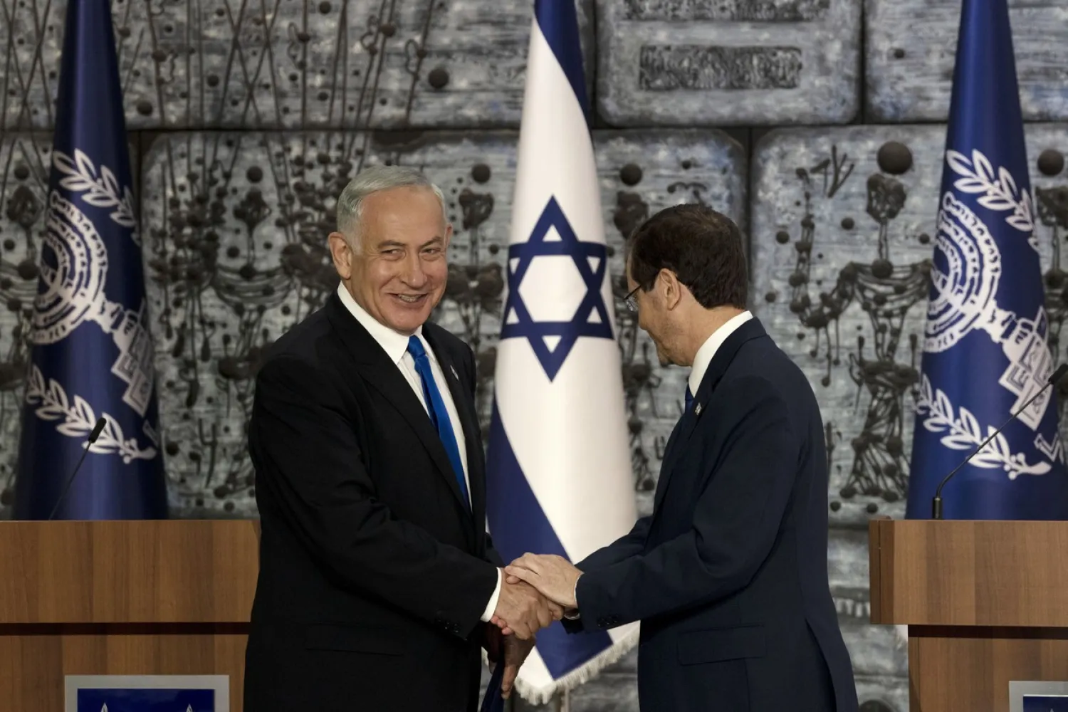  Israel's Likud Party leader Benjamin Netanyahu and President Isaac Herzog shake hands after Herzog assigned Netanyahu the task of forming a government, in Jerusalem, Sunday, Nov. 13, 2022. | Maya Alleruzzo/AP Photo 
