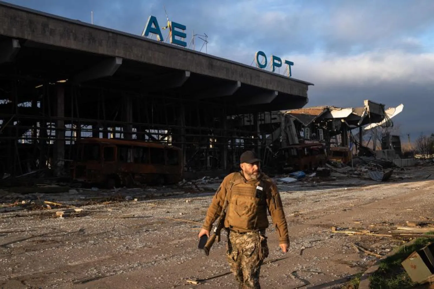 جندي أوكراني يمر بجوار مبنى مدمر في مطار خيرسون الدولي (أ.ف.ب)