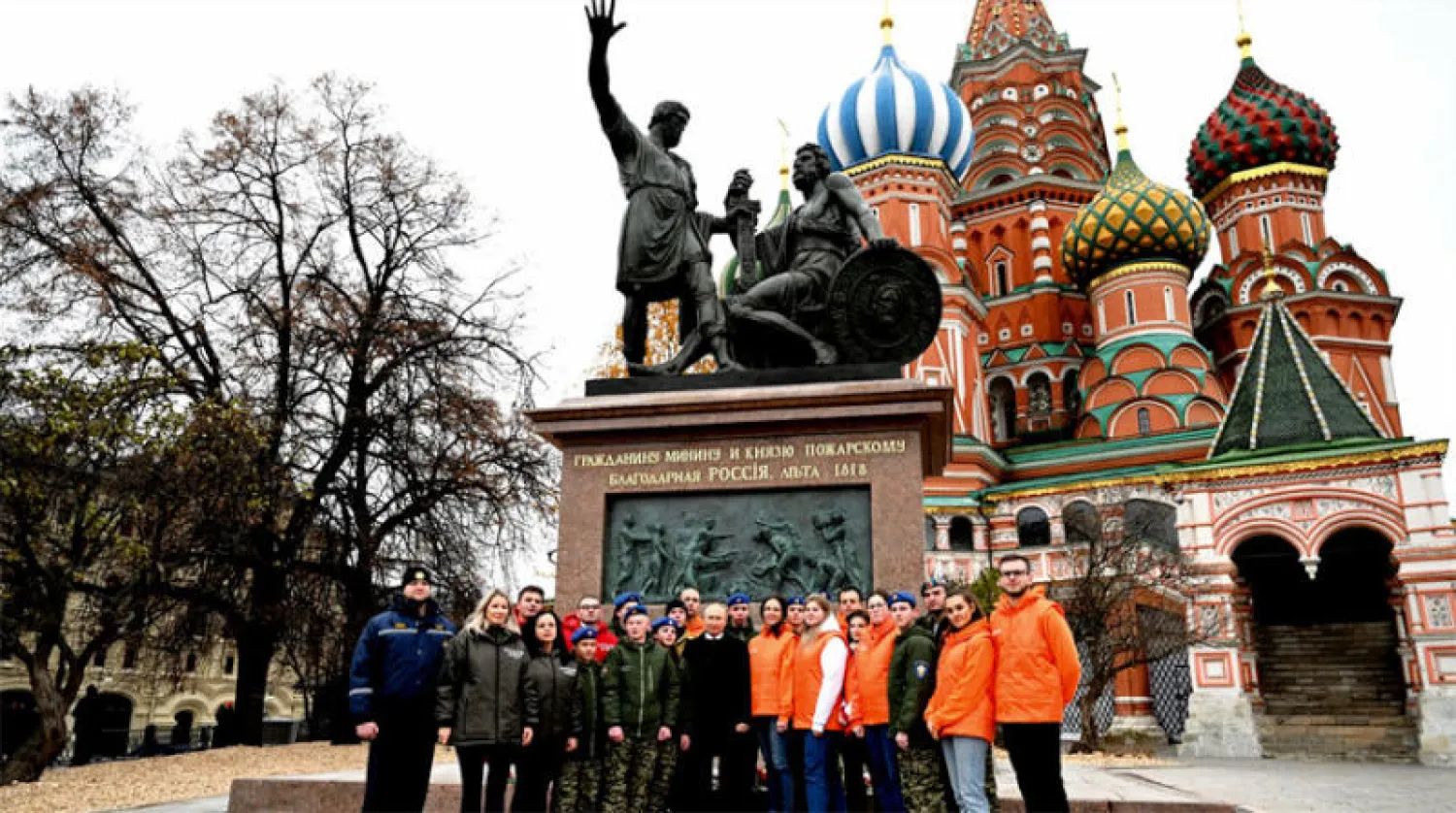 الرئيس الروسي فلاديمير بوتين متوسطاً متطوعين في صورة تذكارية أمام نصب بالساحة الحمراء في موسكو 4 نوفمبر (د.ب.أ)