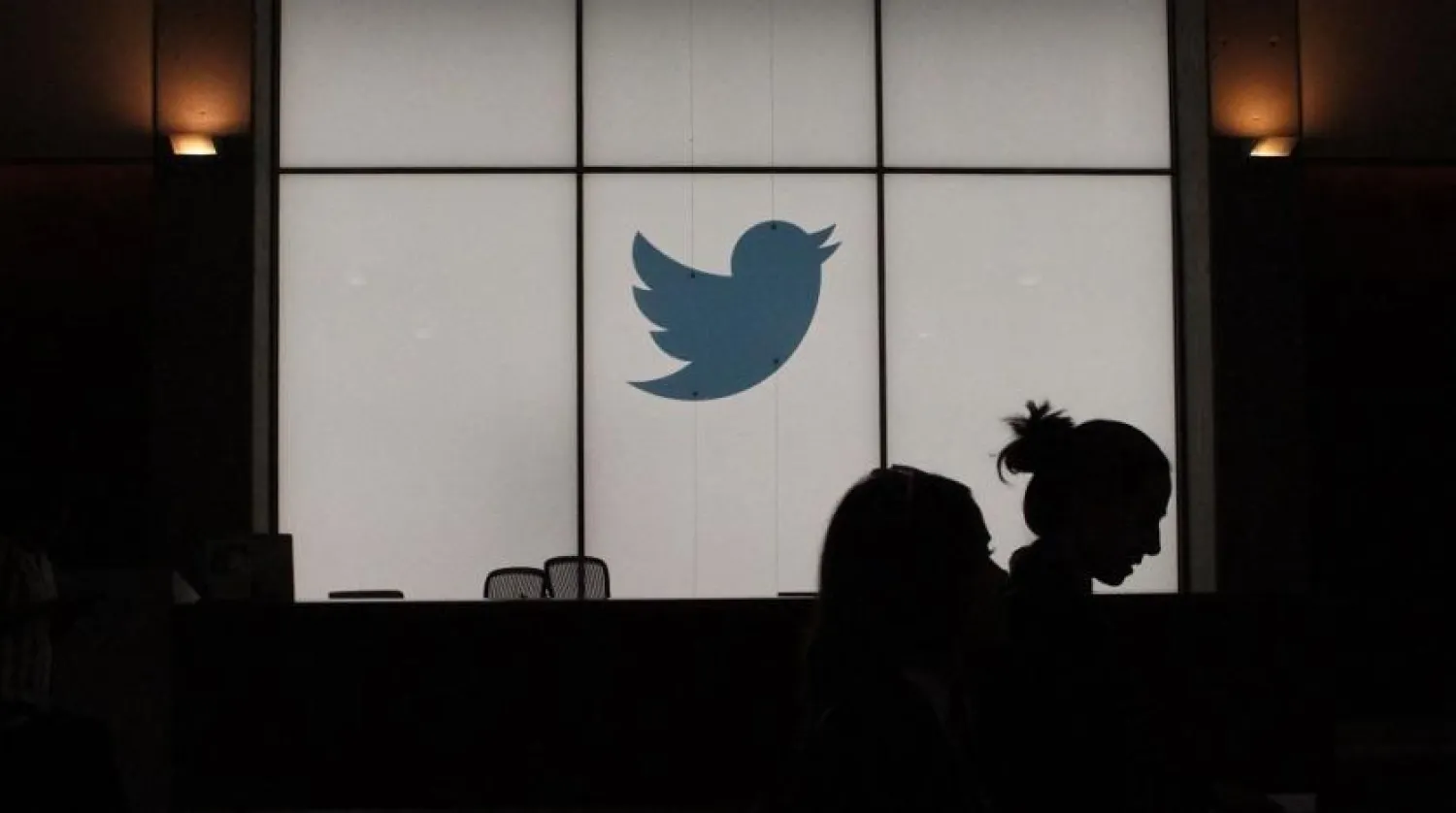 In this file photo taken on August 13, 2019, employees walk past a lighted Twitter log as they leave the company's headquarters in San Francisco. (AFP)
