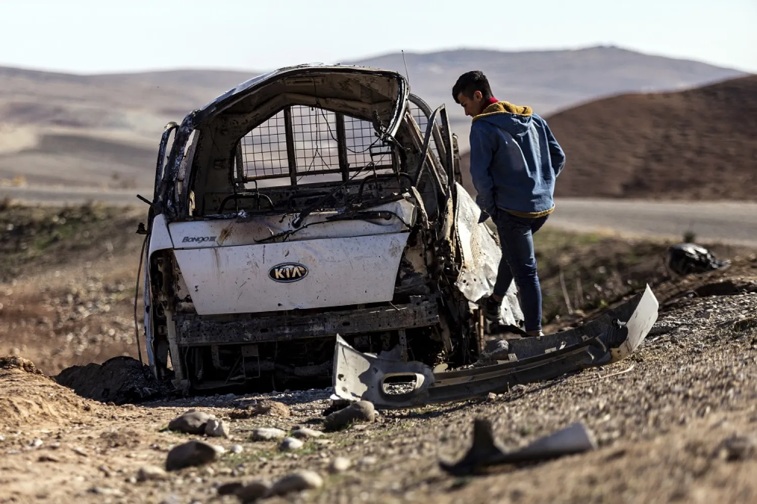 A man inspects a damaged car that hit by Turkish airstrikes near an electricity station in the village of Taql Baql, in Hasakeh province, Syria, Sunday, Nov. 20, 2022. (AP)