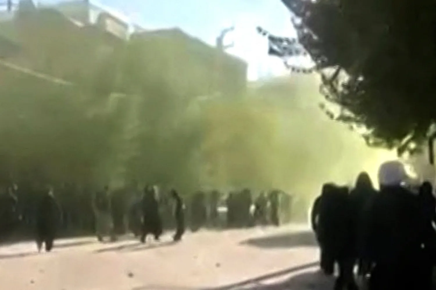 This image grab from UGC video footage posted on November 21, 2022 reportedly shows protesters throwing stones and moving forward amid heavy gunfire on the streets of the Kurdish city of Javanrud, in Iran's western province of Kermanshah. (Photo by UGC / AFP)