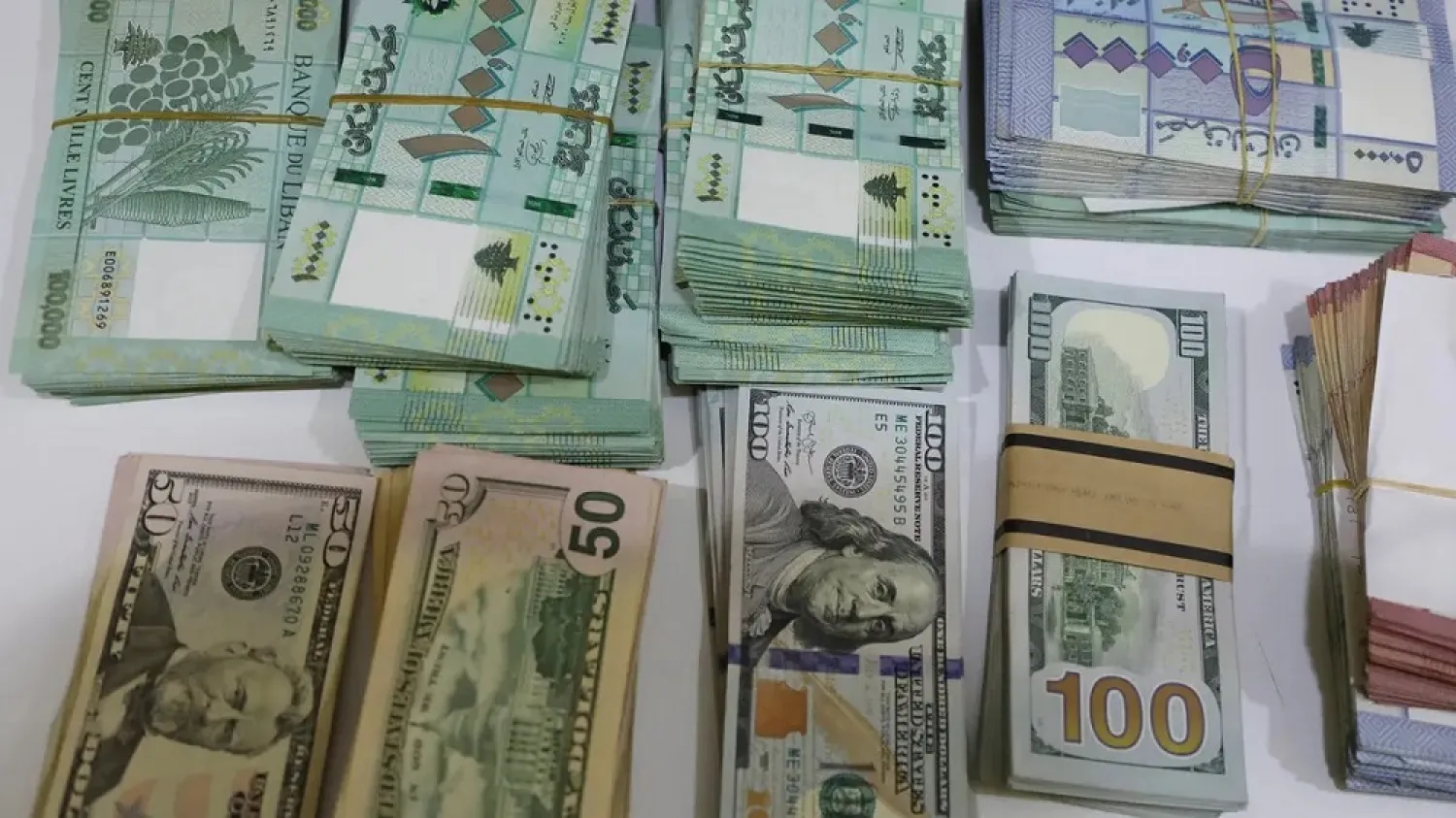 US dollar banknotes and Lebanese pounds are pictured at a currency exchange shop in Beirut, Lebanon March 2, 2021. (Reuters)