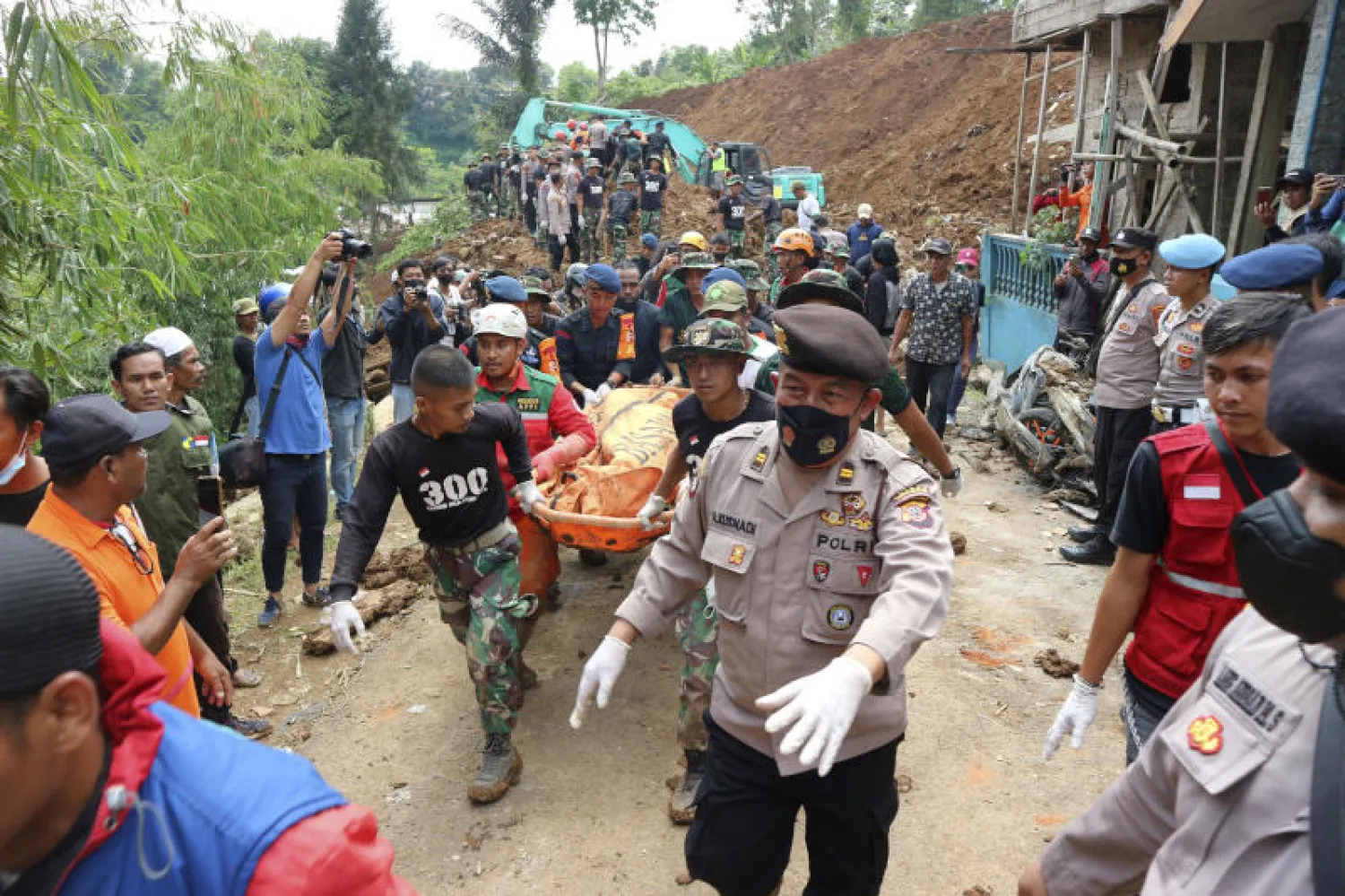 منقذون يحملون إحدى الجثث لضحايا الزلزال في إندونيسيا (أ.ب)