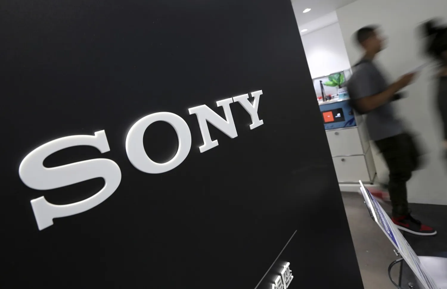 Visitors walk past a logo of Sony at Sony Building in Tokyo, July 31, 2014. (AP)