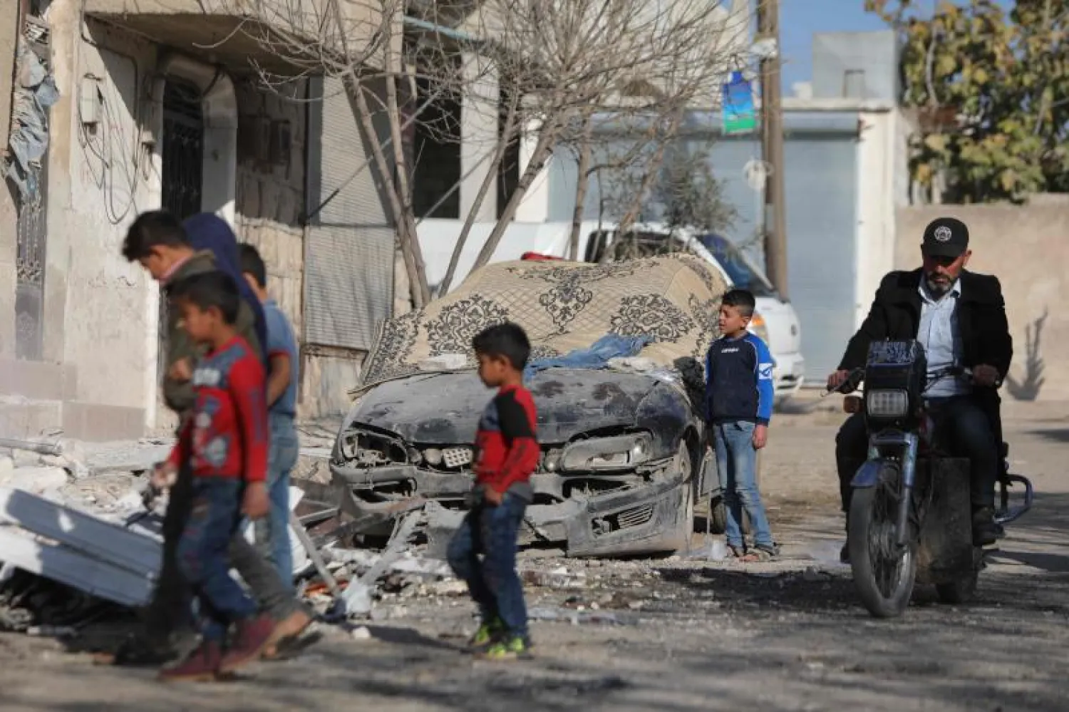 سوريون يتفقدون آثار هجوم صاروخي على بلدة اعزاز شمال محافظة حلب (أ.ف.ب)