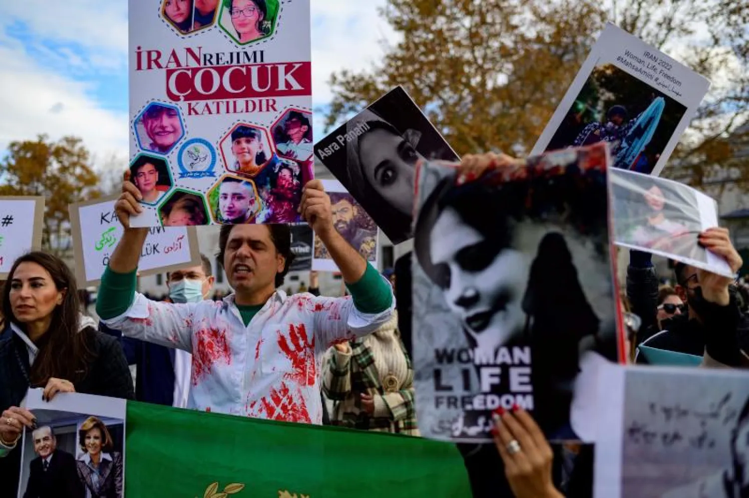 أشخاص يشاركون في مسيرة لدعم الإيرانيات أمس في إسطنبول (أ.ف.ب)