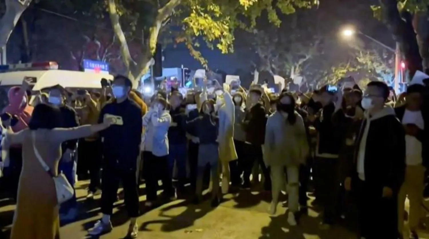 This frame grab from eyewitness video footage made available via AFPTV on November 27, 2022 shows demonstrators shouting slogans in Shanghai. (Photo by AFPTV / AFP)