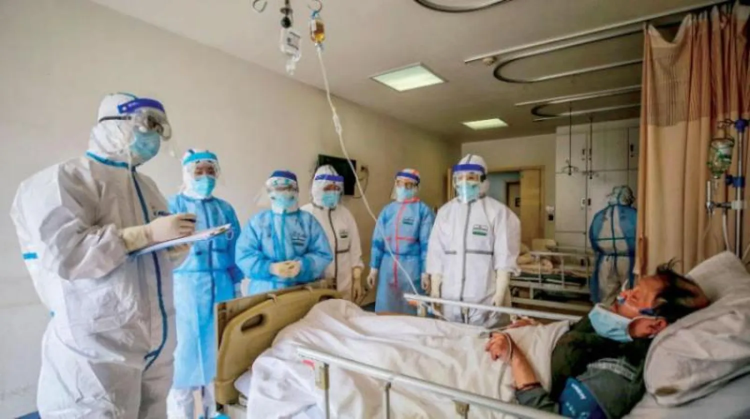 أطباء يتحدثون مع مصاب بـ«كورونا» في مستشفى بالصين (أ.ف.ب)