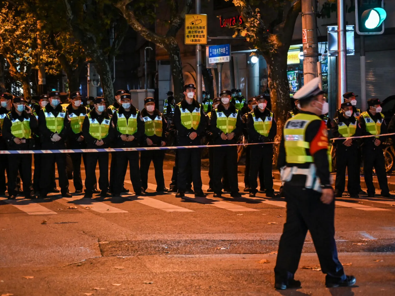 Police officers block Wulumuqi street, named for Urumqi in Mandarin, in Shanghai, where protests have taken place against China's zero-Covid policy Hector RETAMAL AFP

