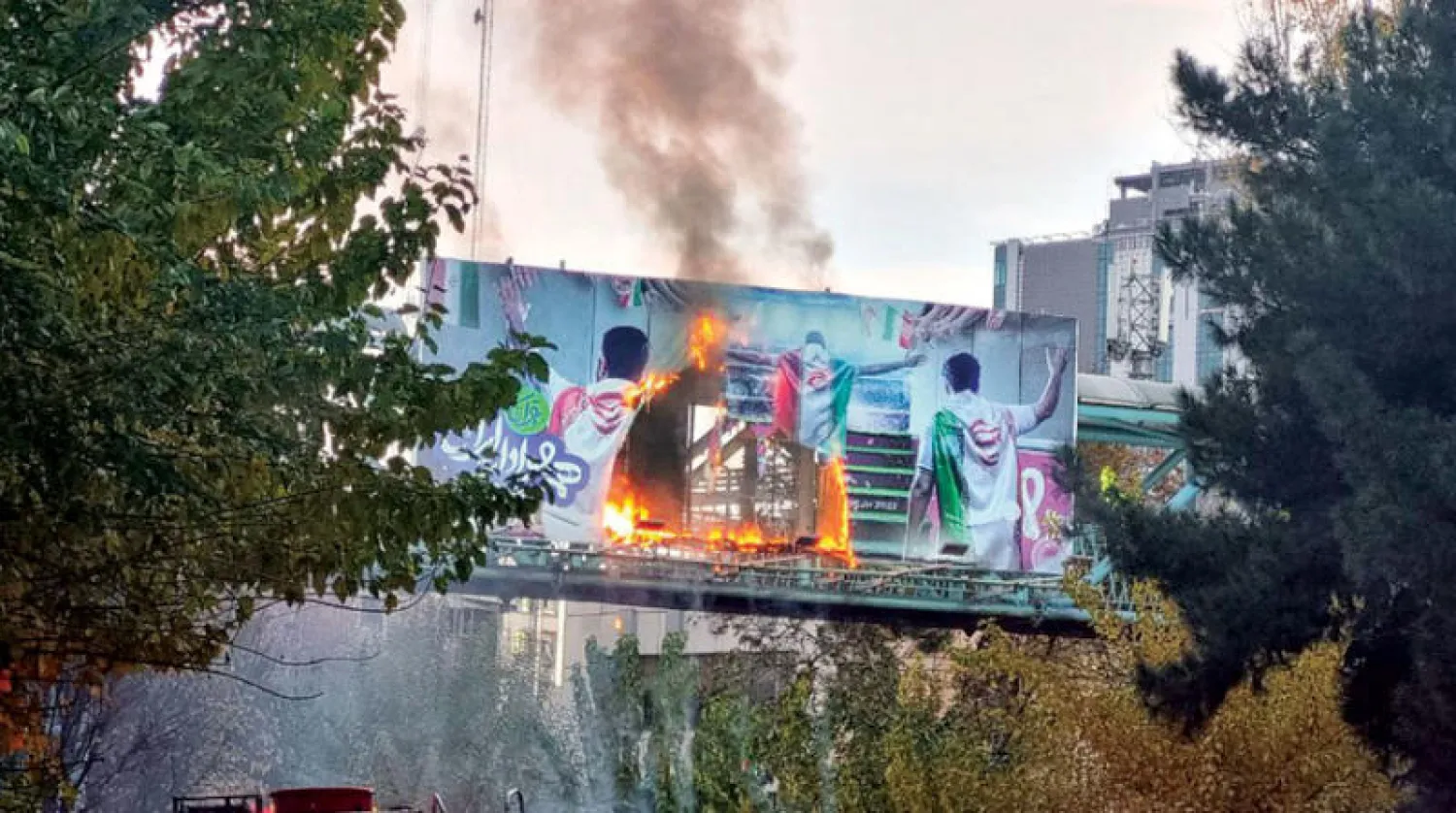 حرق لافتة للمنتخب الإيراني عشية مباراته مع الولايات المتحدة، في طريق سريع وسط طهران (تويتر)