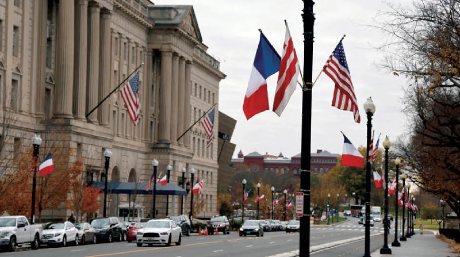 رفع أعلام فرنسية وأميركية أمس في واشنطن تحضيراً لزيارة ماكرون (أ.ف.ب)