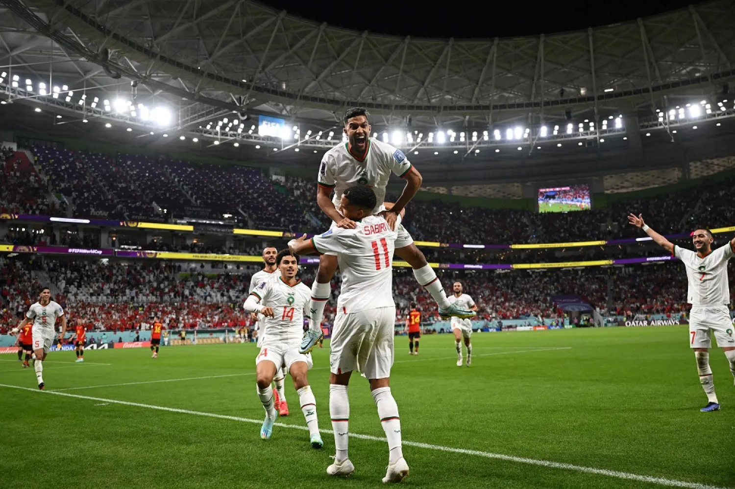 Morocco's midfielder #11 Abdelhamid Sabiri (front) celebrates with teammates after he scored his team's first goal during the Qatar 2022 World Cup Group F football match between Belgium and Morocco at the Al-Thumama Stadium in Doha on November 27, 2022. (AFP)