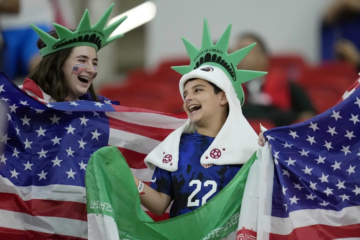 United States football fans hold up American and Iranian flags before the World Cup group B soccer match between Iran and the United States at the Al Thumama Stadium in Doha, Qatar, Tuesday, Nov. 29, 2022. (AP)