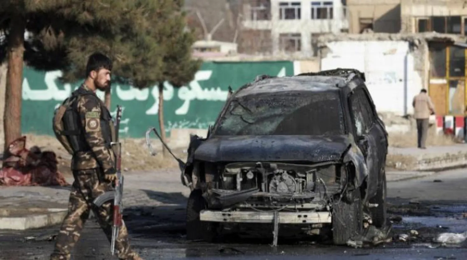 مسؤول أمني أفغاني يتفقد سيارة مدمرة بعد انفجار قنبلة في كابل (أرشيفية-أ.ب)