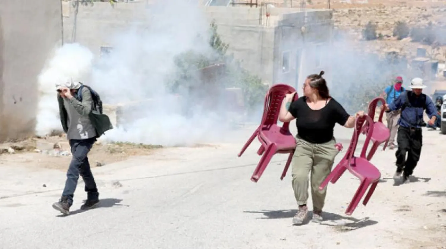 Activists dispersing after the Israeli soldiers fired tear gas near Hebron in September (EPA)
