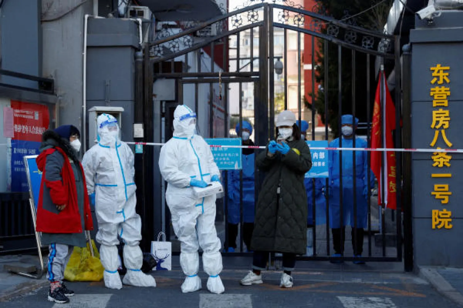 عاملان يرتديان الملابس الواقية من فيروس كورونا في الصين (رويترز)
