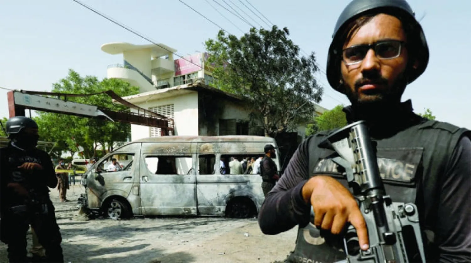 ضباط شرطة يقفون بالقرب من شاحنة ركاب بعد انفجار ارهابي عند مدخل معهد كونفوشيوس بجامعة كراتشي 26 أبريل 2022 (أ.ب.إ)